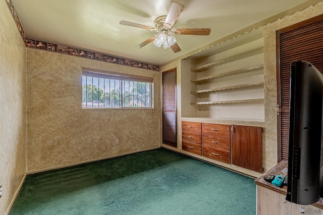 unfurnished room featuring wallpapered walls, ceiling fan, and dark colored carpet