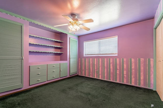 unfurnished bedroom with a ceiling fan and dark carpet