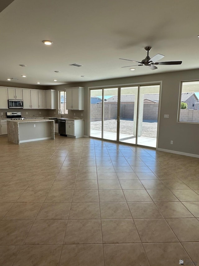 unfurnished living room featuring ceiling fan and light tile patterned floors