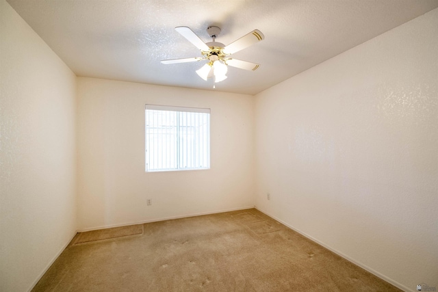 carpeted spare room featuring a textured ceiling and ceiling fan