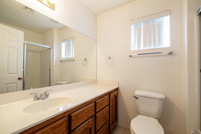 bathroom featuring vanity, toilet, and a shower with shower door