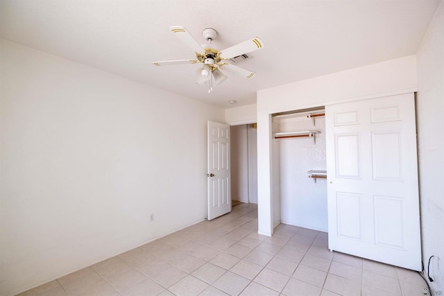 unfurnished bedroom featuring light tile patterned flooring, ceiling fan, and a closet