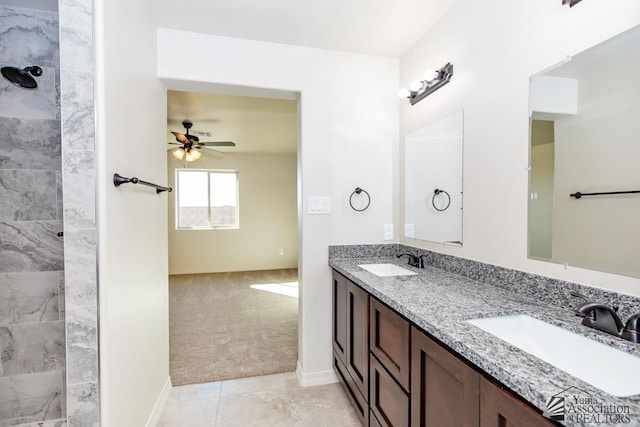 bathroom featuring double vanity, ceiling fan, a sink, and baseboards