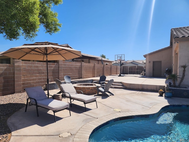 view of swimming pool with an outdoor fire pit and a patio