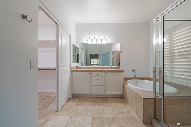 bathroom with plus walk in shower, vanity, and plenty of natural light