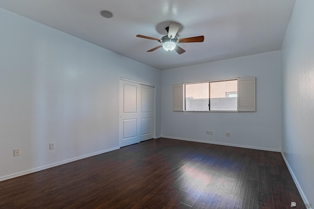 spare room featuring ceiling fan and dark wood-type flooring