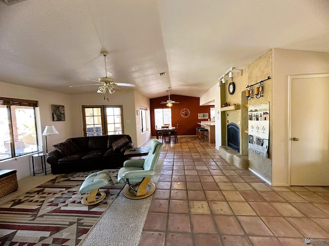 tiled living room with ceiling fan and vaulted ceiling