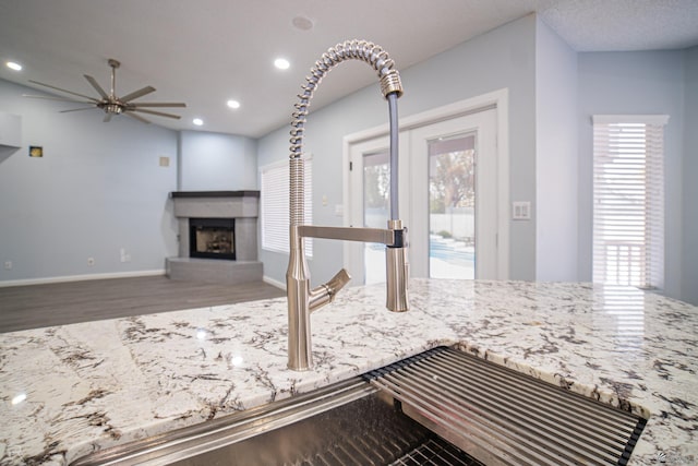 interior space with a fireplace with raised hearth, baseboards, wood finished floors, and recessed lighting