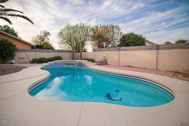 view of pool featuring a fenced backyard and a pool with connected hot tub