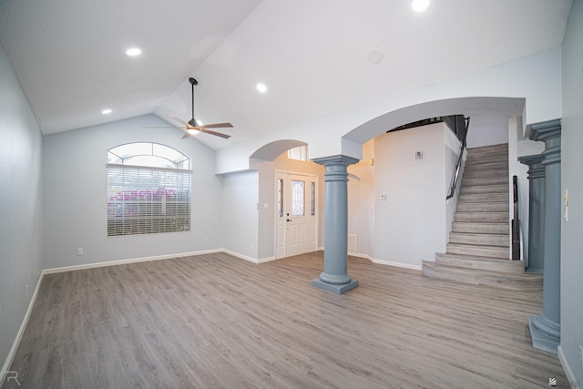 unfurnished living room featuring a healthy amount of sunlight, ornate columns, and arched walkways