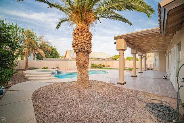 view of swimming pool with a ceiling fan, a patio area, a fenced backyard, and a pool with connected hot tub