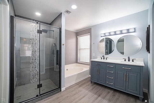 full bathroom with a garden tub, visible vents, a sink, and wood finished floors