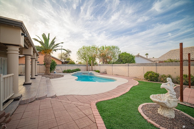 view of swimming pool featuring a patio, a yard, a fenced backyard, and a pool with connected hot tub