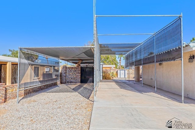 view of patio / terrace with a carport and a storage shed