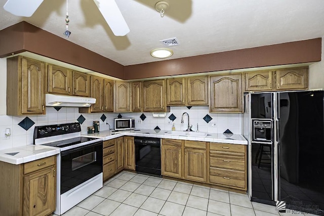 kitchen with decorative backsplash, light tile patterned flooring, and black appliances