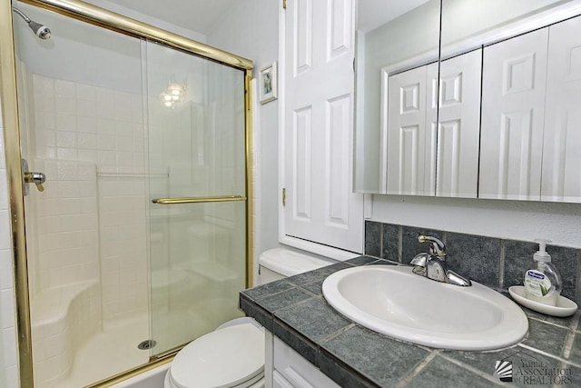 bathroom featuring vanity, backsplash, toilet, and walk in shower