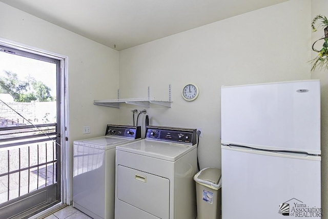 clothes washing area with washer and clothes dryer and light tile patterned floors