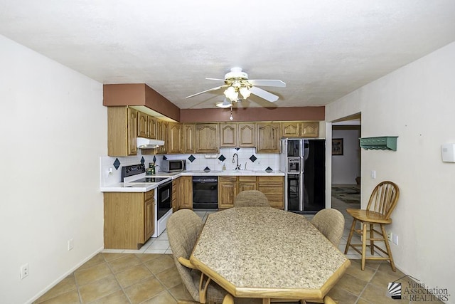 kitchen with tasteful backsplash, ceiling fan, sink, black appliances, and light tile patterned floors