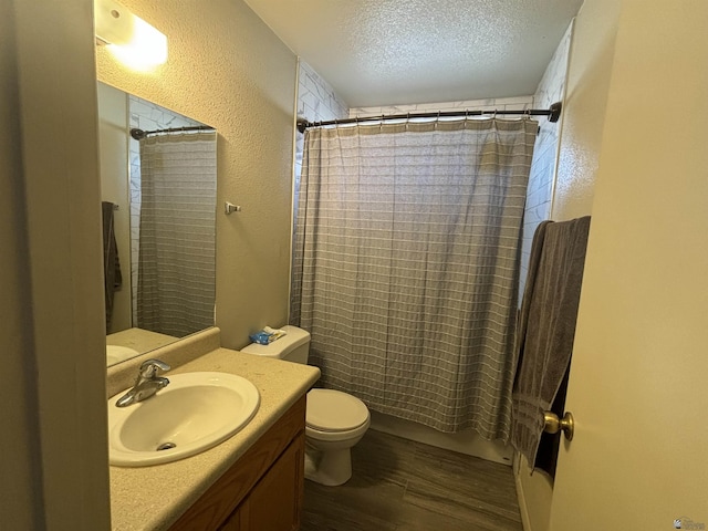 full bathroom with hardwood / wood-style floors, shower / bath combination with curtain, a textured ceiling, toilet, and vanity