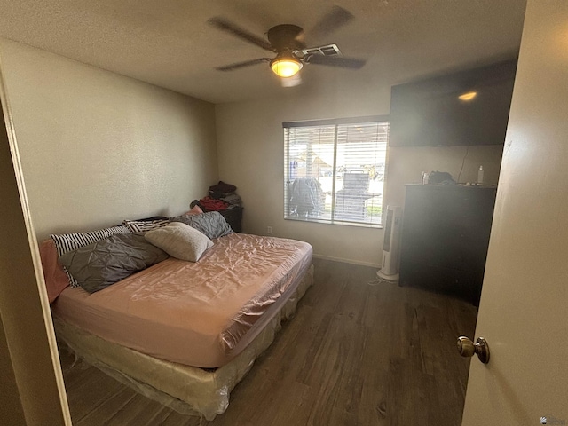 bedroom with ceiling fan and dark wood-type flooring