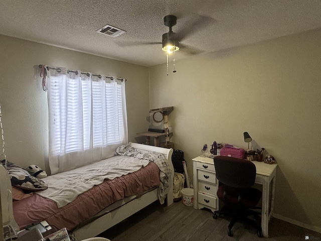 bedroom featuring ceiling fan, dark wood-type flooring, and a textured ceiling