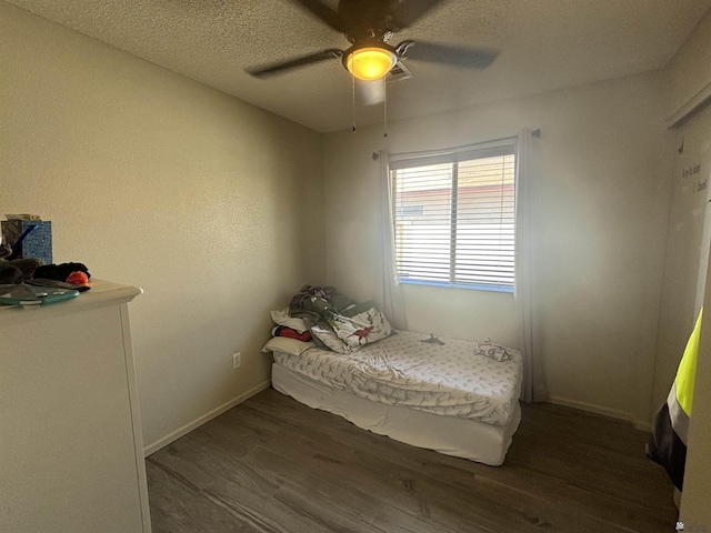 bedroom with ceiling fan, dark hardwood / wood-style flooring, and a textured ceiling