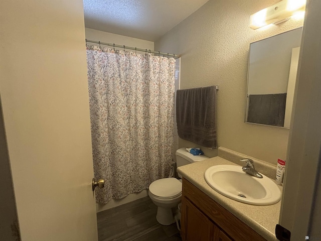 bathroom featuring vanity, toilet, a textured ceiling, walk in shower, and wood-type flooring