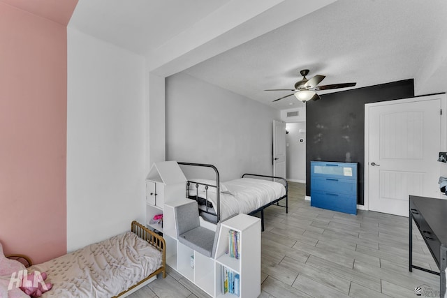 bedroom with wood finish floors, visible vents, ceiling fan, and baseboards