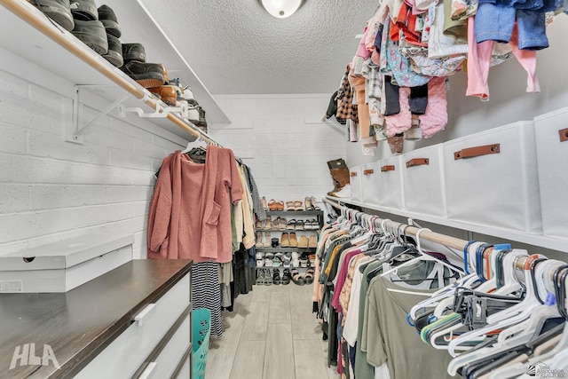 walk in closet with light wood-style flooring