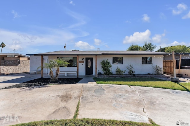 view of front of home featuring stucco siding, fence, and a front yard