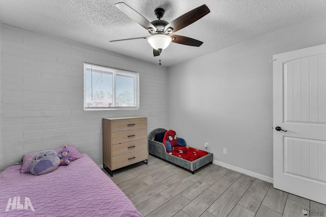 bedroom with wood finish floors, ceiling fan, a textured ceiling, and baseboards