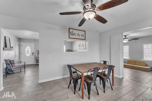 dining area featuring a textured ceiling, wood finish floors, and baseboards