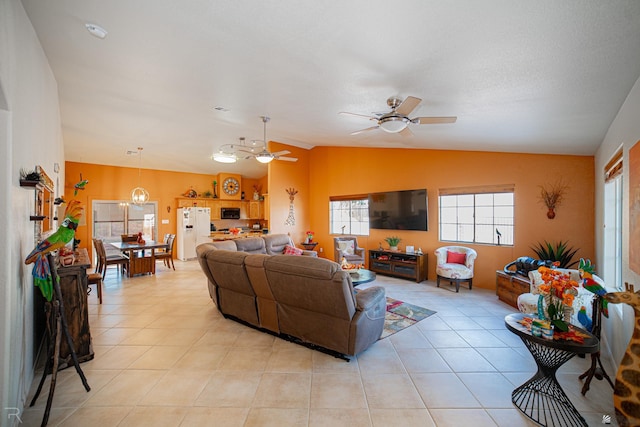 living room featuring ceiling fan, light tile patterned flooring, and lofted ceiling