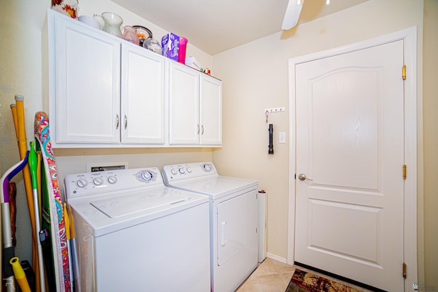 clothes washing area with cabinets, light tile patterned floors, and washing machine and clothes dryer