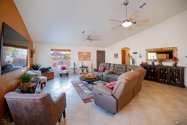 tiled living room with ceiling fan, plenty of natural light, and vaulted ceiling