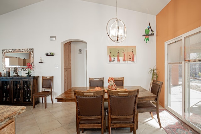 tiled dining area featuring high vaulted ceiling and a chandelier