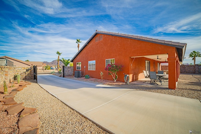 view of home's exterior with cooling unit, a patio area, and ceiling fan