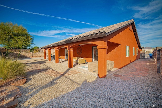 view of side of property featuring an outdoor hangout area, a patio, and ceiling fan