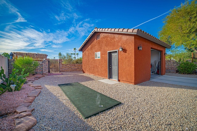 rear view of house with a garage and an outdoor structure