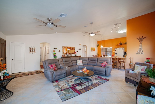 living room featuring lofted ceiling, ceiling fan, and light tile patterned floors