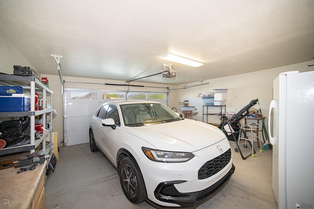 garage with white refrigerator and a garage door opener