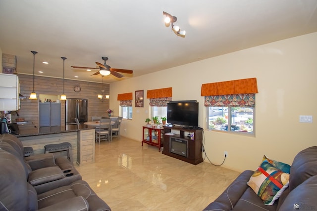 living room with ceiling fan and wood walls