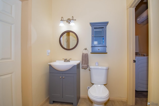 bathroom with washer / clothes dryer, vanity, a wall mounted AC, and toilet