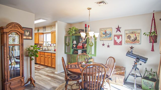 dining area featuring a chandelier, light hardwood / wood-style floors, and sink