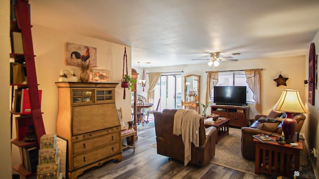 living room with ceiling fan and dark wood-type flooring