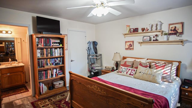 bedroom featuring hardwood / wood-style floors, ceiling fan, and sink