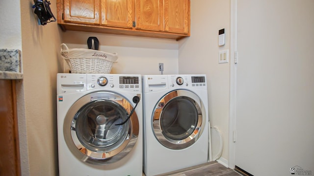 clothes washing area with hardwood / wood-style flooring, cabinets, and independent washer and dryer