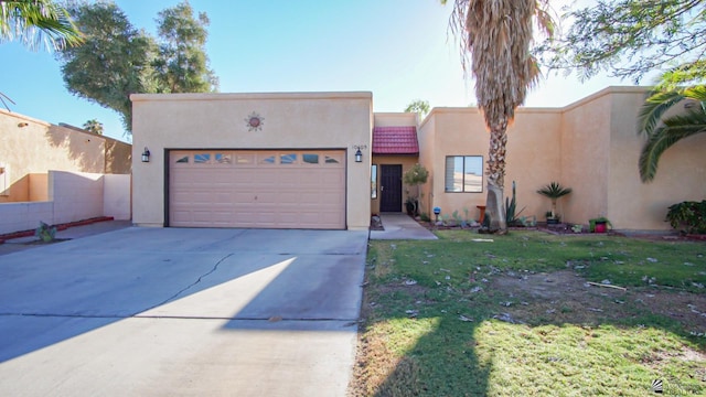 pueblo revival-style home with a front yard and a garage