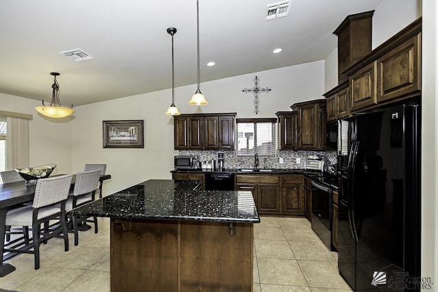 kitchen with pendant lighting, a center island, and black appliances