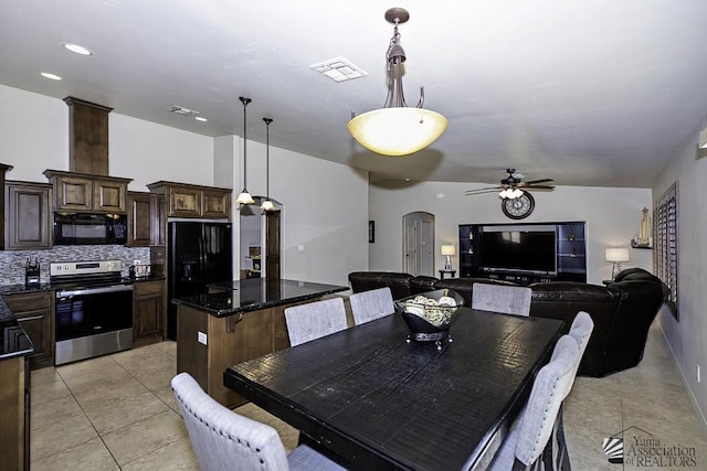 dining space with ceiling fan, light tile patterned floors, and ornate columns